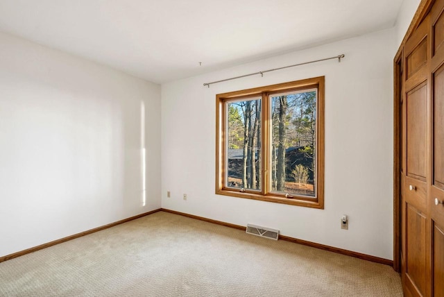empty room with light carpet and baseboards