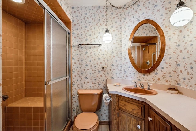 bathroom featuring wallpapered walls, a stall shower, toilet, and vanity