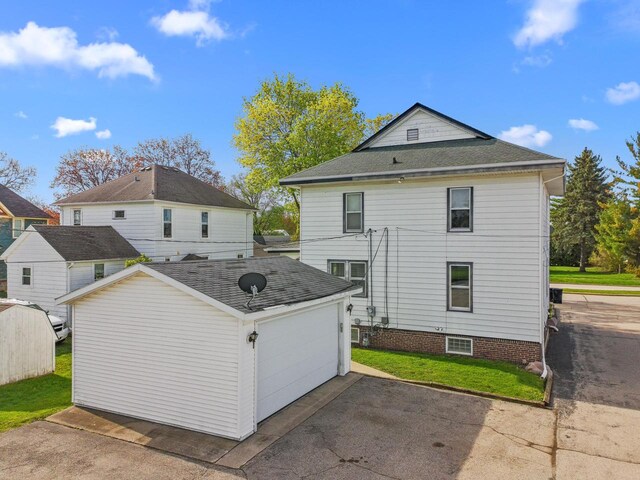 210 E Walworth St, Elkhorn, WI 53121 - back of property with an outdoor structure, a yard, and a detached garage