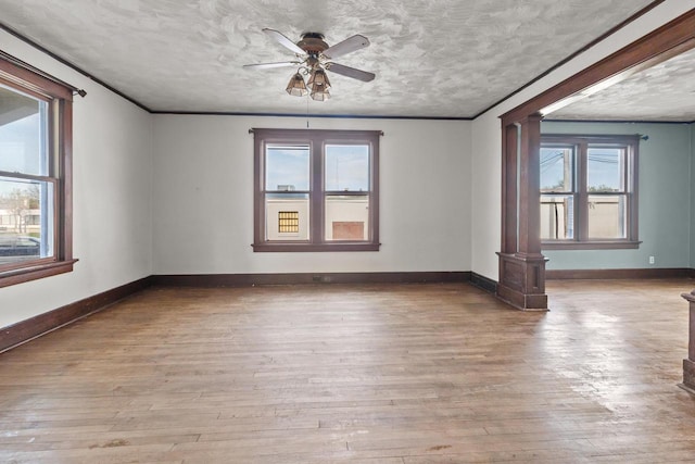 210 E Walworth St, Elkhorn, WI 53121 - unfurnished room featuring ornate columns, hardwood / wood-style flooring, ceiling fan, a textured ceiling, and baseboards