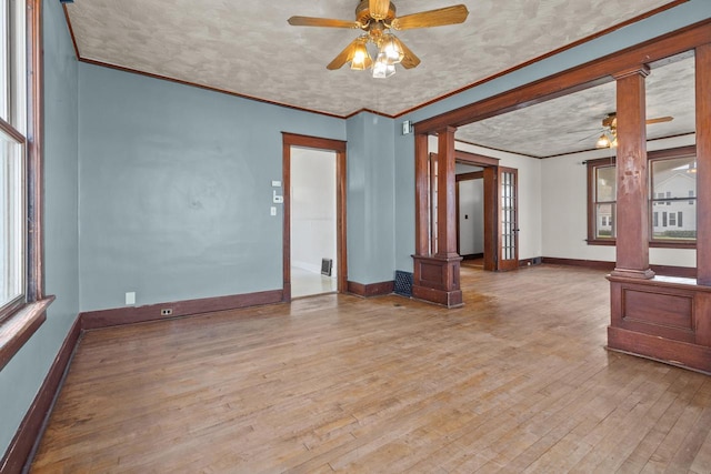 210 E Walworth St, Elkhorn, WI 53121 - spare room featuring ornate columns, ceiling fan, baseboards, hardwood / wood-style floors, and ornamental molding