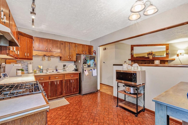 5803 N 77th St, Milwaukee, WI 53218 - kitchen with appliances with stainless steel finishes, brown cabinetry, light countertops, a sink, and baseboards