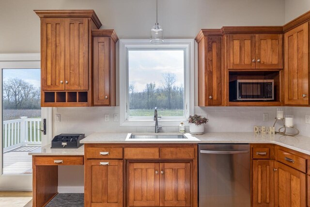 kitchen featuring stainless steel appliances, a sink, brown cabinets, backsplash, and light countertops