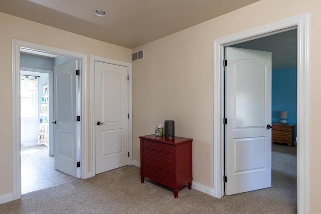 hallway featuring carpet flooring and baseboards