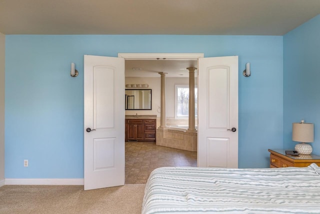 bedroom featuring baseboards, carpet flooring, and a sink