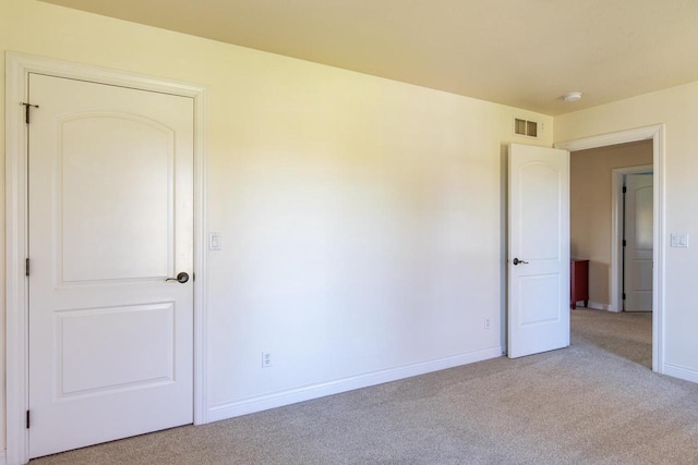 carpeted empty room featuring baseboards