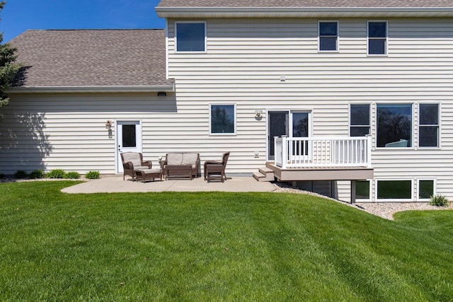 back of property with outdoor lounge area, a yard, a patio area, and roof with shingles