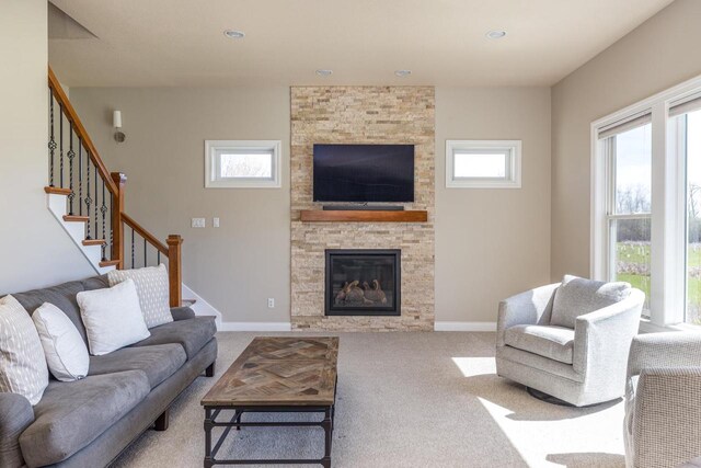 carpeted living area with stairs, a fireplace, baseboards, and recessed lighting