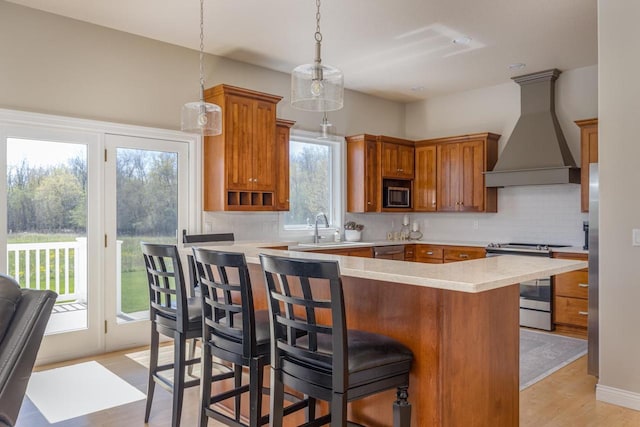 kitchen with stainless steel appliances, custom exhaust hood, a sink, light countertops, and tasteful backsplash