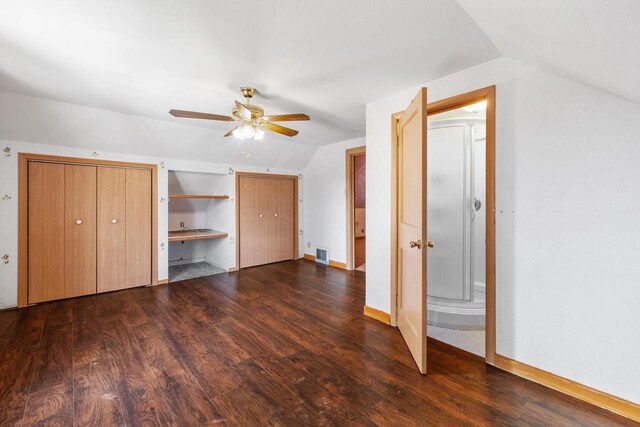 1214 S 17th St, Sheboygan, WI 53081 - unfurnished bedroom with vaulted ceiling, dark wood finished floors, two closets, and ceiling fan