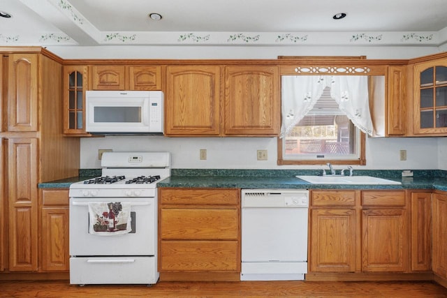 1214 S 17th St, Sheboygan, WI 53081 - kitchen with white appliances, a sink, glass insert cabinets, brown cabinetry, and dark countertops