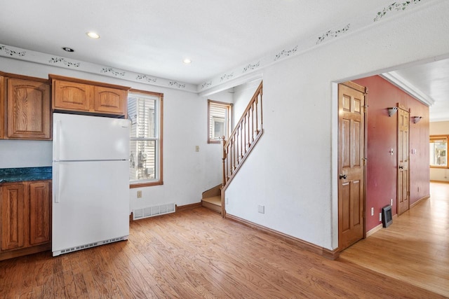 1214 S 17th St, Sheboygan, WI 53081 - kitchen with freestanding refrigerator, light wood-style floors, brown cabinetry, baseboards, and recessed lighting