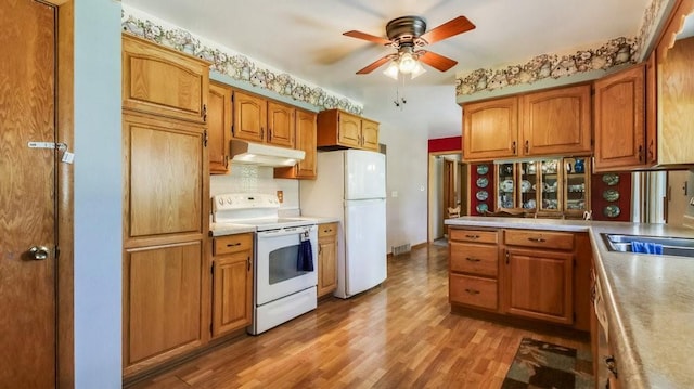 3710 Mcelroy St, Eau Claire, WI 54701 - kitchen with white appliances, under cabinet range hood, ceiling fan, tasteful backsplash, and a sink