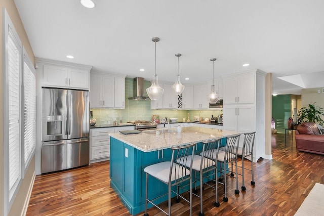 W11055 Eagle Dr, Lodi, WI 53555 - kitchen with appliances with stainless steel finishes, wall chimney range hood, dark wood finished floors, white cabinets, and backsplash