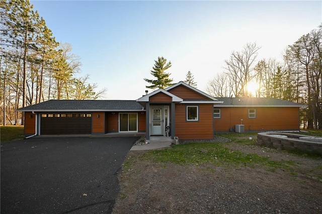W5937 Ross Rd, Trego, WI 54888 - single story home with cooling unit, a garage, and asphalt driveway
