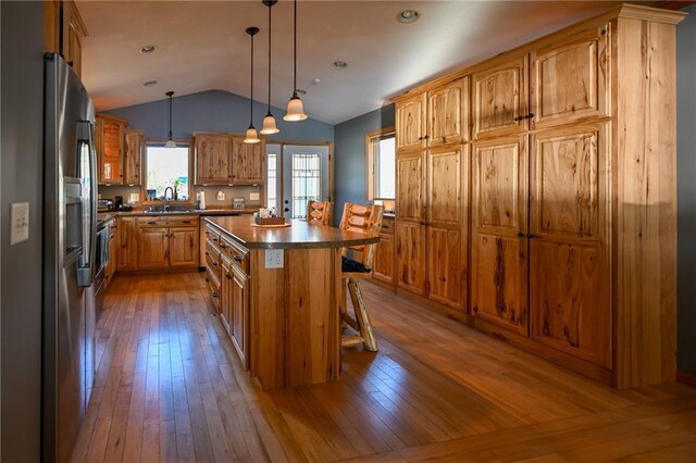 W5937 Ross Rd, Trego, WI 54888 - kitchen featuring stainless steel fridge with ice dispenser, dark countertops, a sink, vaulted ceiling, and a kitchen bar