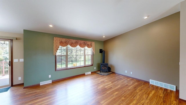 421 John Michael Dr, Jefferson, WI 53549 - unfurnished room featuring healthy amount of natural light, light wood-type flooring, a wood stove, and recessed lighting