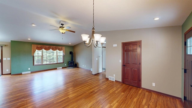 421 John Michael Dr, Jefferson, WI 53549 - unfurnished dining area featuring a wood stove, light wood finished floors, a ceiling fan, a chandelier, and baseboards