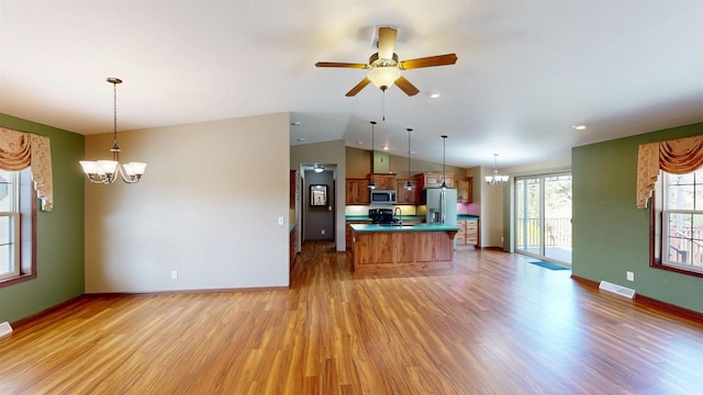 421 John Michael Dr, Jefferson, WI 53549 - kitchen featuring appliances with stainless steel finishes, a chandelier, a sink, light wood-type flooring, and vaulted ceiling