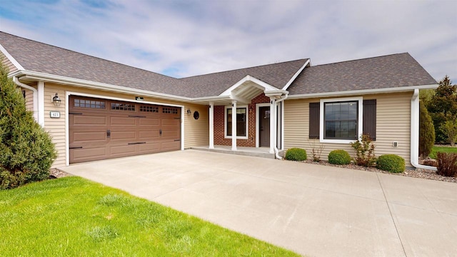 421 John Michael Dr, Jefferson, WI 53549 - single story home featuring concrete driveway, an attached garage, a shingled roof, a front yard, and covered porch