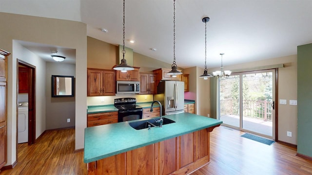 421 John Michael Dr, Jefferson, WI 53549 - kitchen featuring stainless steel appliances, a sink, light wood-type flooring, lofted ceiling, and brown cabinetry