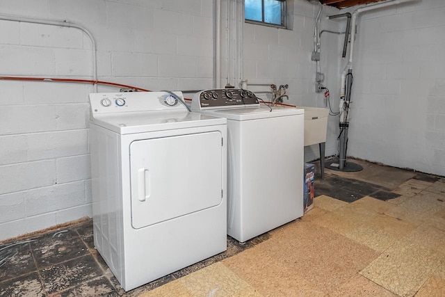 laundry room with washing machine and dryer, concrete block wall, and tile patterned floors