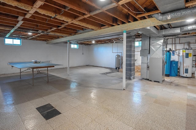 below grade area featuring water heater, heating unit, and tile patterned floors