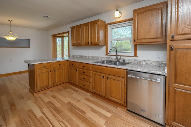 kitchen featuring stainless steel dishwasher, a sink, a peninsula, light countertops, and light wood-style flooring