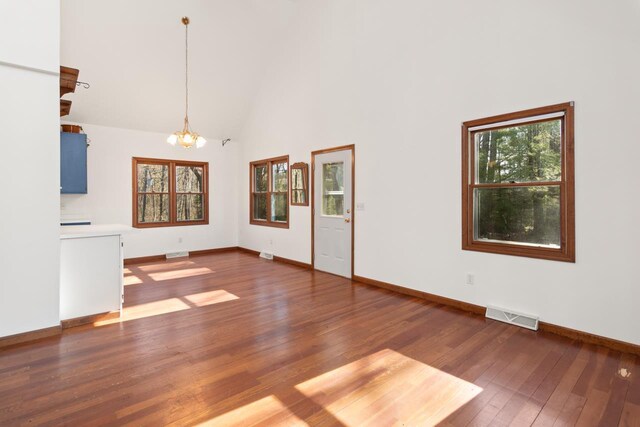 6615 Birchwood Shores Ln, Oconto Falls, WI 54154 - unfurnished living room with a chandelier, hardwood / wood-style floors, baseboards, and high vaulted ceiling