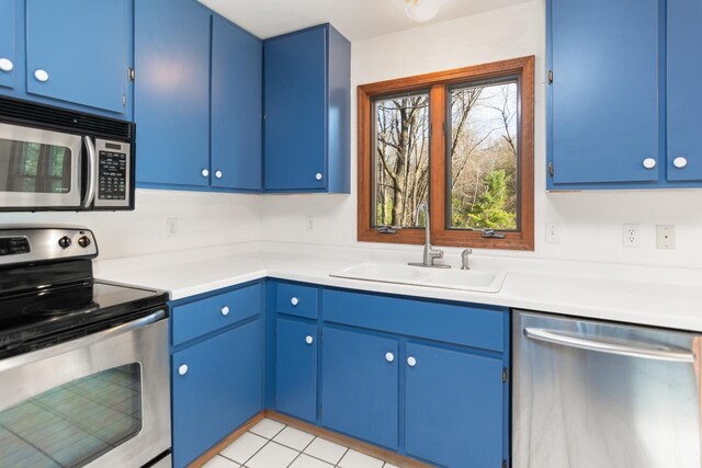 6615 Birchwood Shores Ln, Oconto Falls, WI 54154 - kitchen with appliances with stainless steel finishes, a sink, blue cabinetry, and light countertops