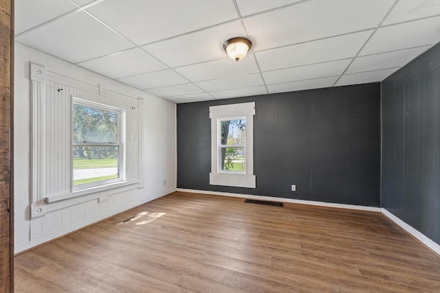 332 La Valle St, Reedsburg, WI 53959 - unfurnished room featuring plenty of natural light, wood finished floors, a drop ceiling, baseboards, and wooden walls