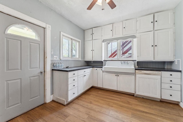 332 La Valle St, Reedsburg, WI 53959 - kitchen with dishwasher, a sink, light wood-style floors, dark countertops, and a ceiling fan