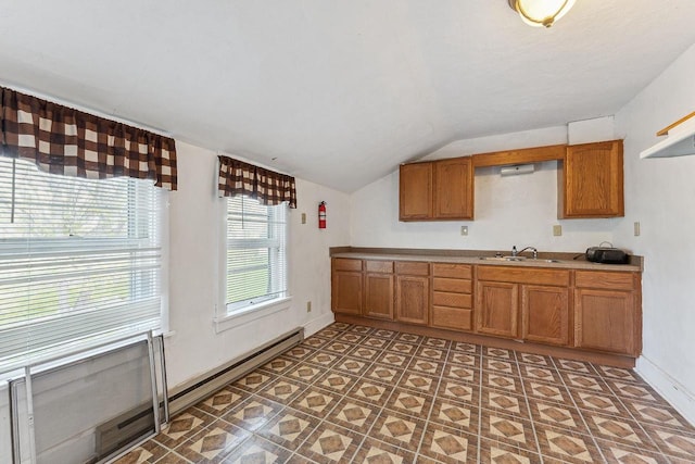 332 La Valle St, Reedsburg, WI 53959 - kitchen featuring vaulted ceiling, a sink, brown cabinetry, light countertops, and baseboards