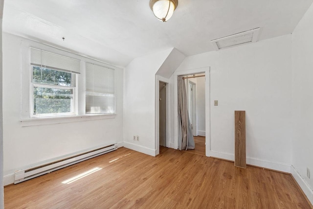 332 La Valle St, Reedsburg, WI 53959 - additional living space featuring a baseboard heating unit, attic access, light wood-style flooring, lofted ceiling, and baseboards