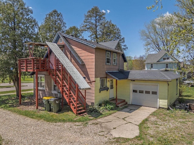 332 La Valle St, Reedsburg, WI 53959 - view of front of house with a shingled roof, driveway, stairs, and a wooden deck