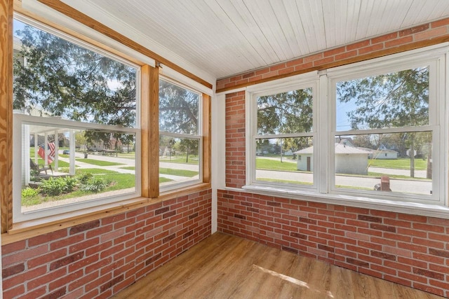 332 La Valle St, Reedsburg, WI 53959 - unfurnished sunroom with brick wall, wood finished floors, and plenty of natural light