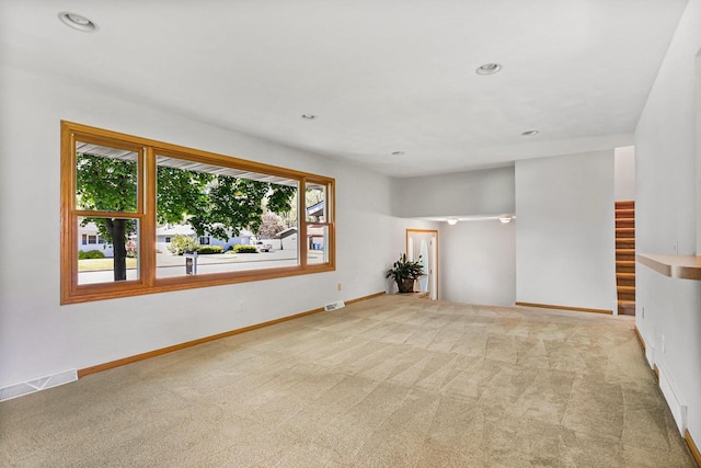 407 Edward St, Verona, WI 53593 - empty room featuring healthy amount of natural light, carpet floors, recessed lighting, baseboards, and stairs