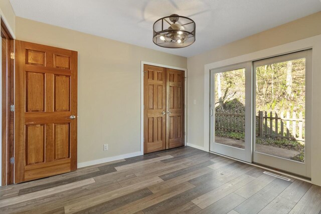 W5685 Koss Rd, Onalaska, WI 54650 - unfurnished bedroom featuring access to exterior, wood finished floors, baseboards, and a closet