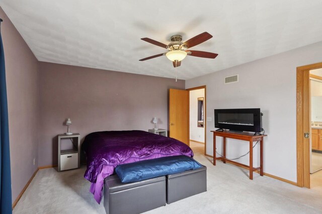 7938 E Hwy 59, Milton, WI 53563 - bedroom featuring light carpet, baseboards, a ceiling fan, and ensuite bathroom