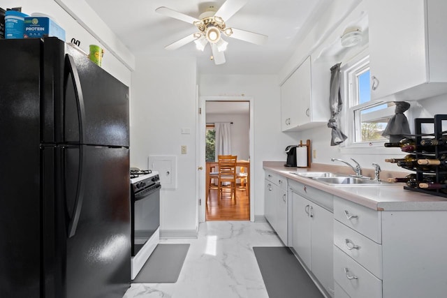 9517 W Capitol Dr, Milwaukee, WI 53222 - kitchen with freestanding refrigerator, range with gas cooktop, light marble finish flooring, a sink, and white cabinets