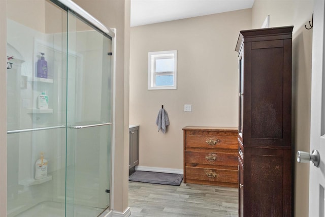 657 Elm St, Black River Falls, WI 54615 - bathroom with a stall shower, vanity, wood finished floors, and baseboards