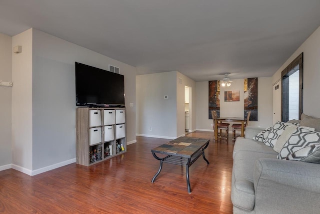 living room with wood finished floors, a ceiling fan, and baseboards
