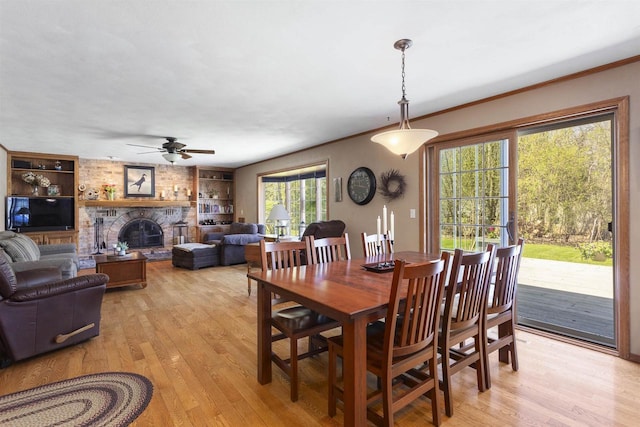 37 Pheasant Ct, Appleton, WI 54915 - dining area with ceiling fan, built in shelves, light wood-style floors, ornamental molding, and a large fireplace