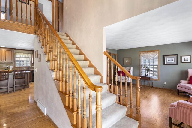 37 Pheasant Ct, Appleton, WI 54915 - stairway with wood finished floors, a high ceiling, and baseboards