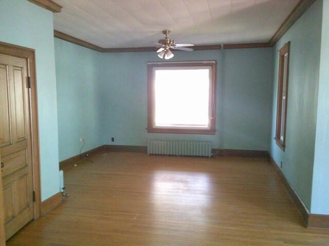 2309 Jefferson St, Two Rivers, WI 54241 - spare room with radiator, light wood finished floors, baseboards, ceiling fan, and crown molding