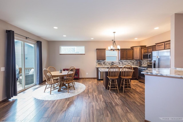 222 Blooming Leaf Way, Verona, WI 53593 - dining space featuring dark wood-style floors, healthy amount of natural light, recessed lighting, a chandelier, and baseboards