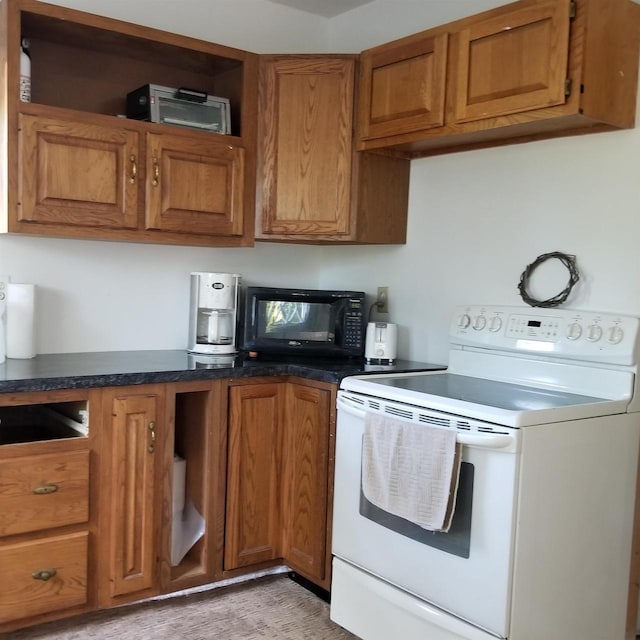 N15601 12th Ave, Necedah, WI 54646 - kitchen with white electric stove, brown cabinetry, black microwave, dark countertops, and light wood-type flooring