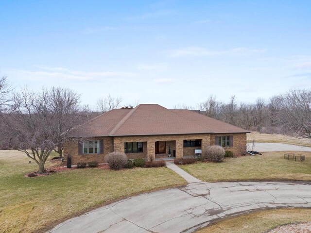 2108 Lawrence Dr, De Pere, WI 54115 - ranch-style home featuring a front yard, brick siding, a porch, and roof with shingles