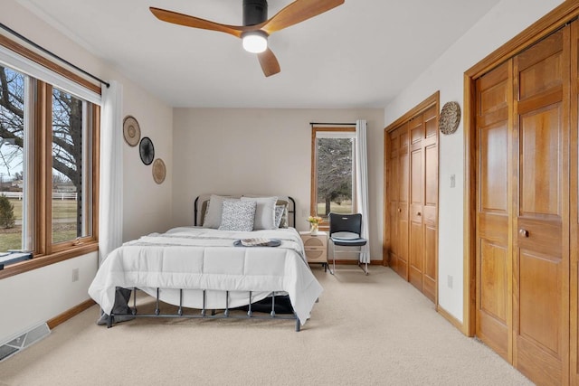2108 Lawrence Dr, De Pere, WI 54115 - bedroom featuring light colored carpet, multiple closets, baseboards, and a ceiling fan