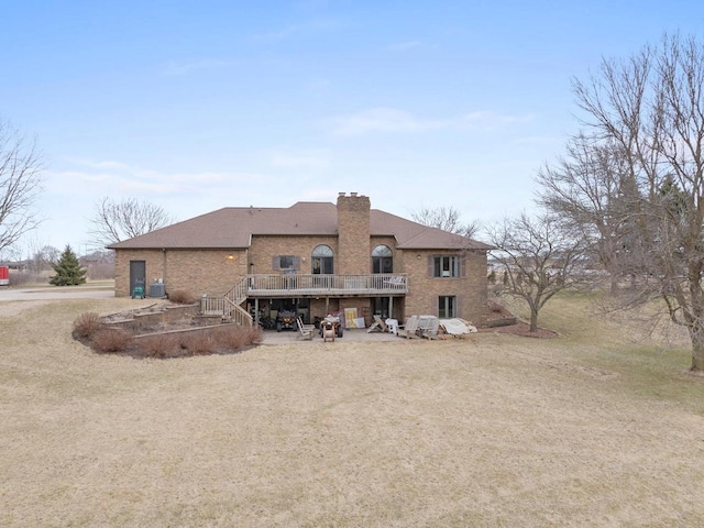 2108 Lawrence Dr, De Pere, WI 54115 - rear view of property featuring a deck, stairs, a chimney, brick siding, and a shingled roof